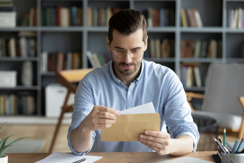 Personne lisant un courrier de rappel d'invitation